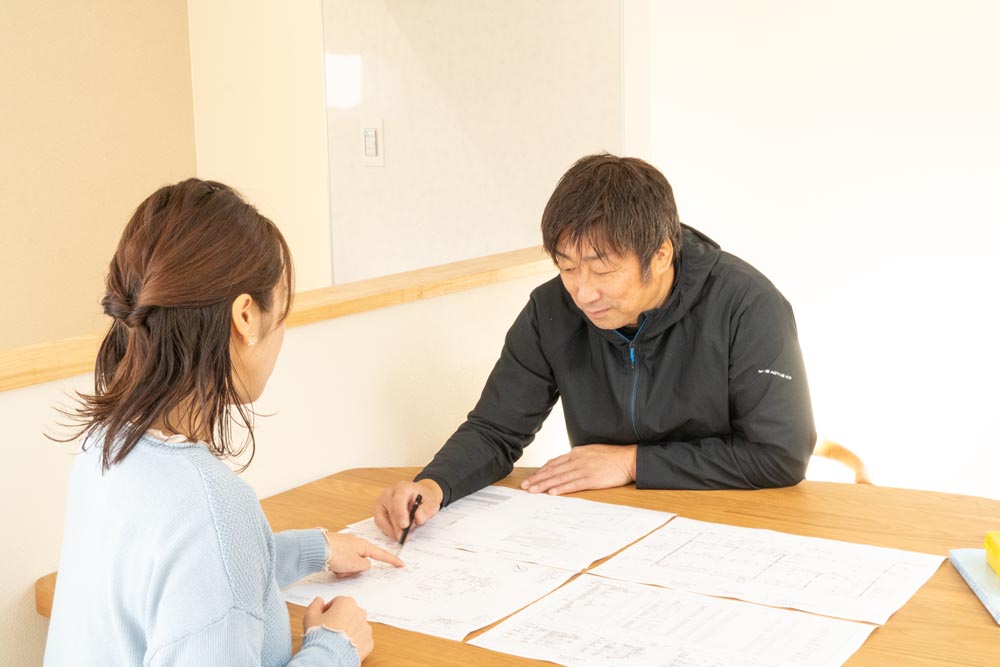 お客様と打ち合わせをしているスタッフの写真